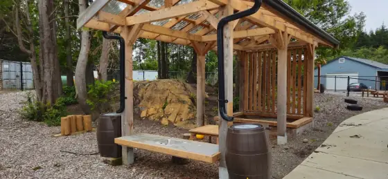 Close-up of the outdoor mud kitchen sink and rain barrels at Comfort First Early Learning